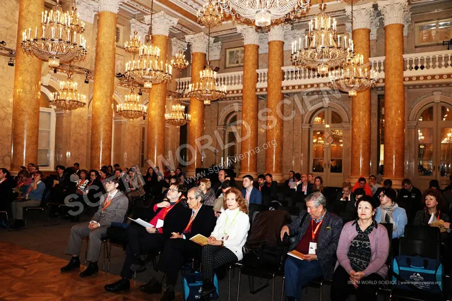 An audience beneath the chandeliers